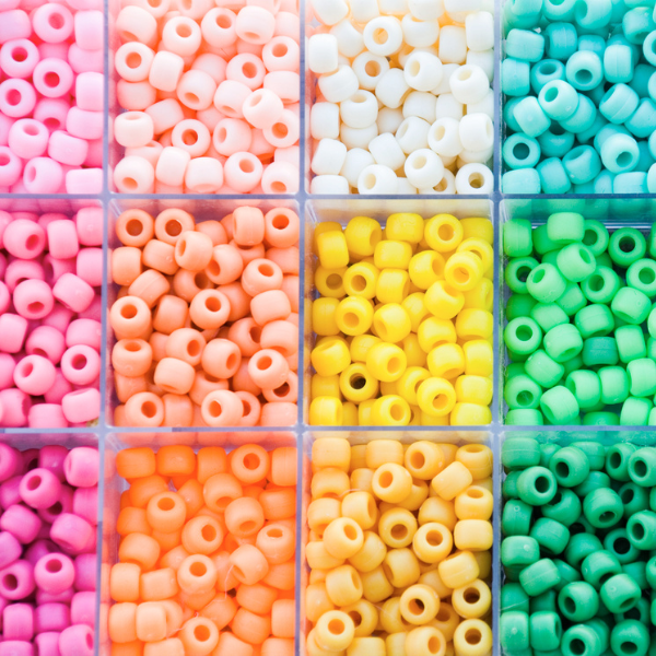 A container of pony beads separated by colors. 