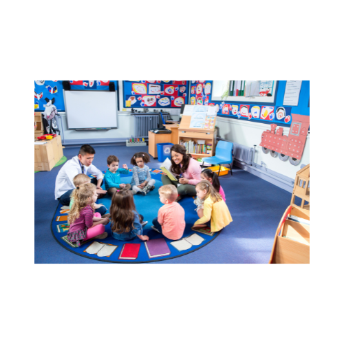 group of children and two adults sitting in circle on a rug in a heartily decorated classroom or meeting room.  Main color is blue.