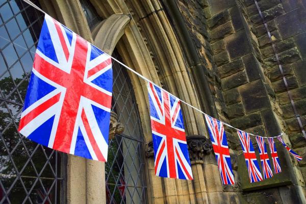 British flags hanging in front of a Gothic window